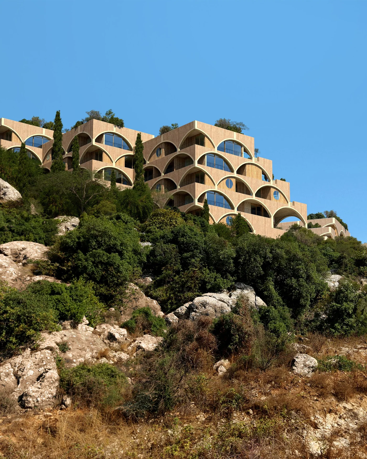 The village on the rocky hill under a blue sky