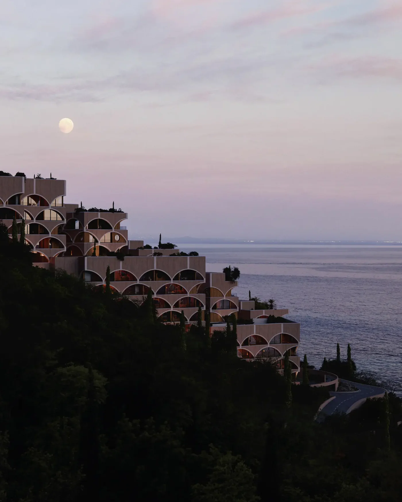The village at dusk with the moon over the sea