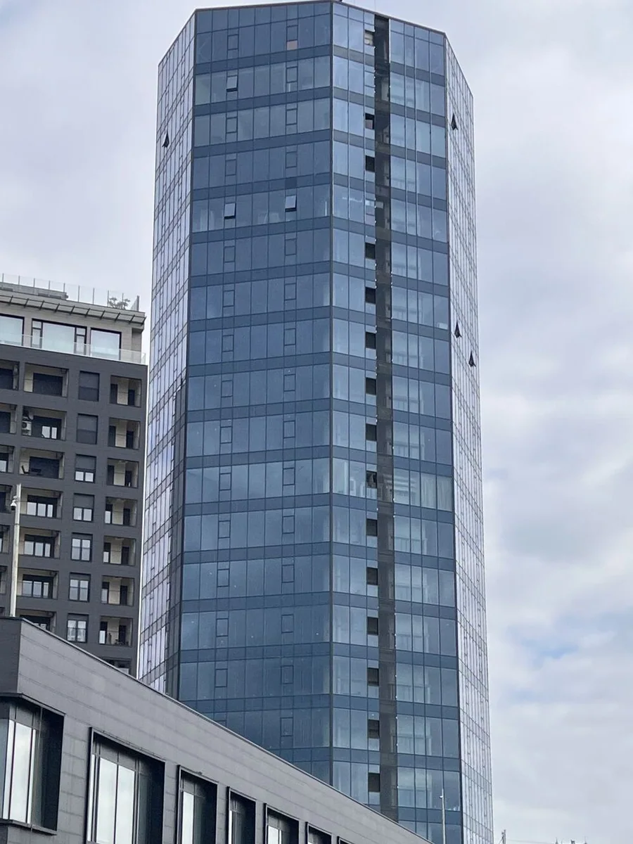 Dukagjini Center from the street: the glass tower beside the residence, above the shops
