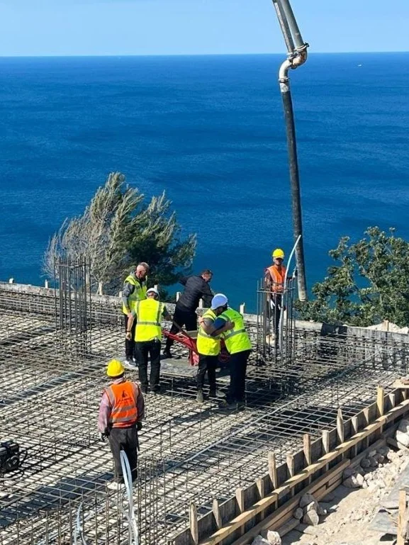 Workers on the reinforcement at the foundation laying of Dukagjini Resort, the Adriatic behind
